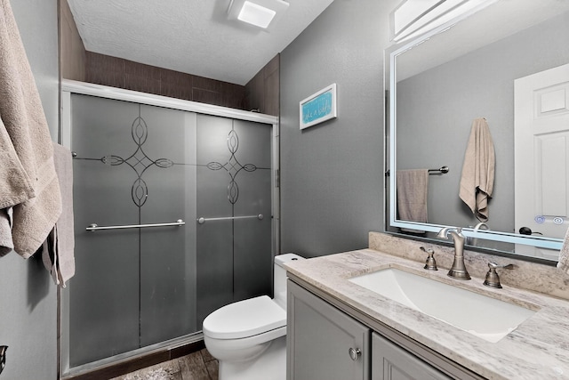 9616 Eucariz Ave SW, Albuquerque, NM 87121 - bathroom featuring vanity, a stall shower, wood finished floors, and a textured ceiling