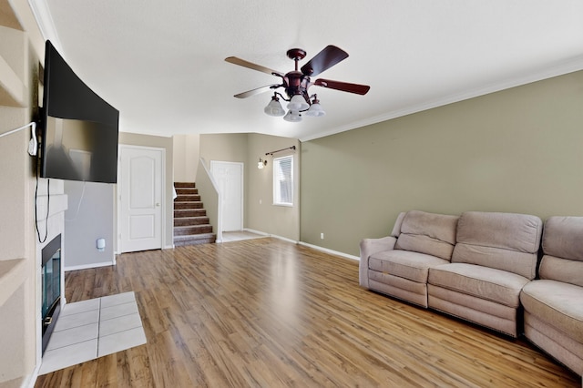 701 Autumn Meadows Dr, Rio Rancho, NM 87144 - living room with ceiling fan, stairway, wood finished floors, a glass covered fireplace, and ornamental molding