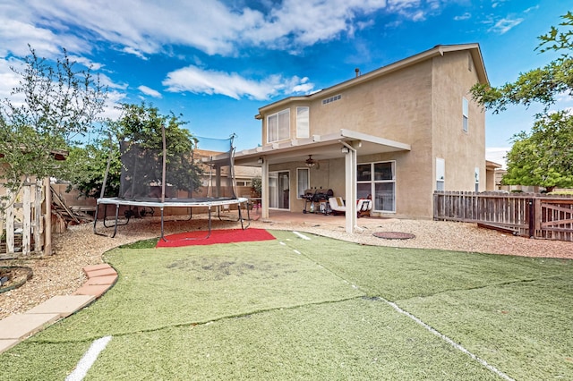 701 Autumn Meadows Dr, Rio Rancho, NM 87144 - back of property featuring a trampoline, stucco siding, a patio, a fenced backyard, and ceiling fan