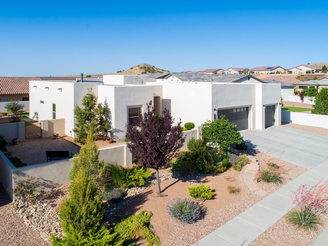 1978 Castle Peak Loop NE, Rio Rancho, NM 87144 - view of front facade with an attached garage, a gate, stucco siding, and driveway