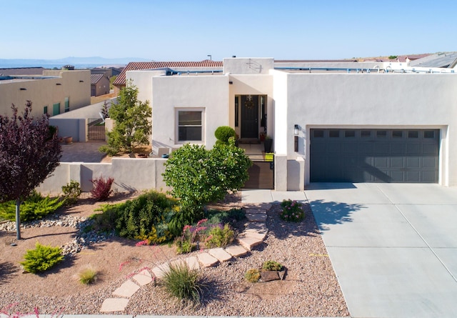 1978 Castle Peak Loop NE, Rio Rancho, NM 87144 - pueblo revival-style home featuring stucco siding, concrete driveway, and a gate