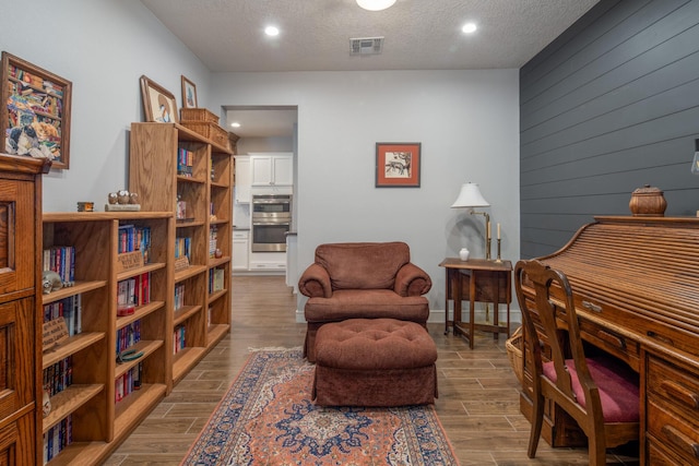 1978 Castle Peak Loop NE, Rio Rancho, NM 87144 - sitting room featuring wood finished floors, recessed lighting, a textured ceiling, and wood walls