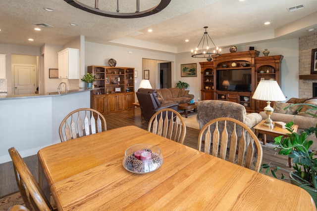 1978 Castle Peak Loop NE, Rio Rancho, NM 87144 - dining area with wood finished floors, a textured ceiling, a chandelier, recessed lighting, and a brick fireplace