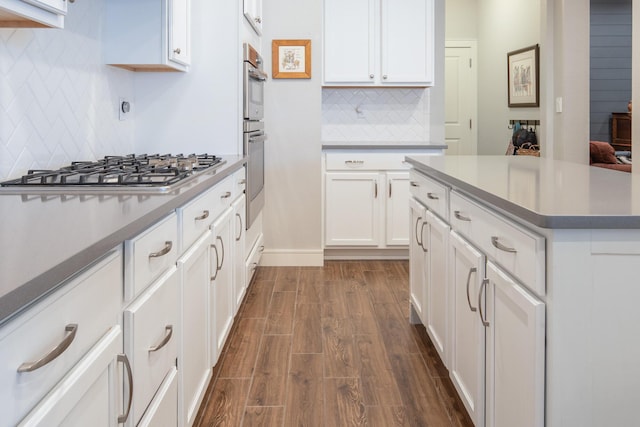 1978 Castle Peak Loop NE, Rio Rancho, NM 87144 - kitchen with stainless steel gas cooktop, backsplash, dark wood finished floors, and white cabinetry