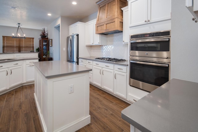1978 Castle Peak Loop NE, Rio Rancho, NM 87144 - kitchen with appliances with stainless steel finishes, custom exhaust hood, dark wood-style floors, recessed lighting, and tasteful backsplash