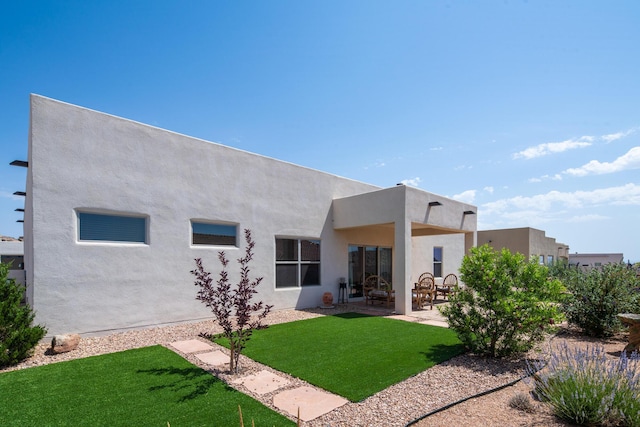 1978 Castle Peak Loop NE, Rio Rancho, NM 87144 - back of property with a patio area, stucco siding, and a lawn