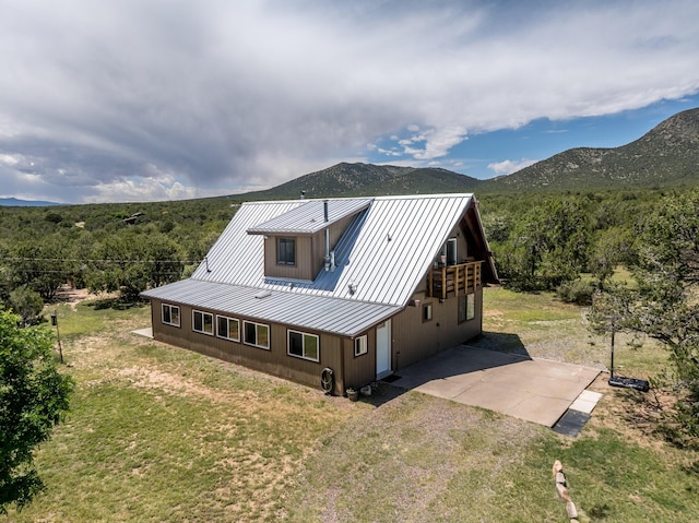 1 Dinosaur Rd, Stanley, NM 87056 - back of house featuring a metal roof, a view of trees, a patio, and a mountain view