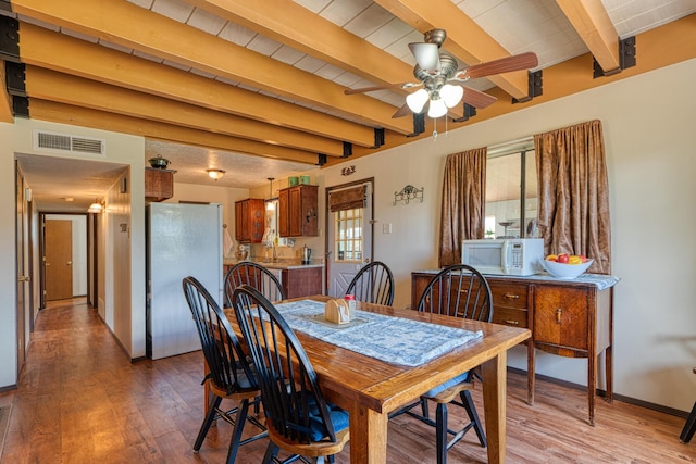 1 Dinosaur Rd, Stanley, NM 87056 - dining area featuring light wood finished floors, a ceiling fan, and beam ceiling