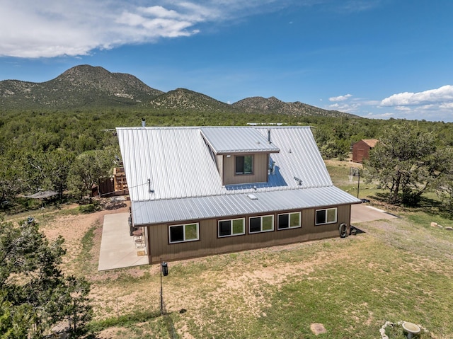 1 Dinosaur Rd, Stanley, NM 87056 - view of property exterior with a mountain view, a metal roof, a yard, and a patio area