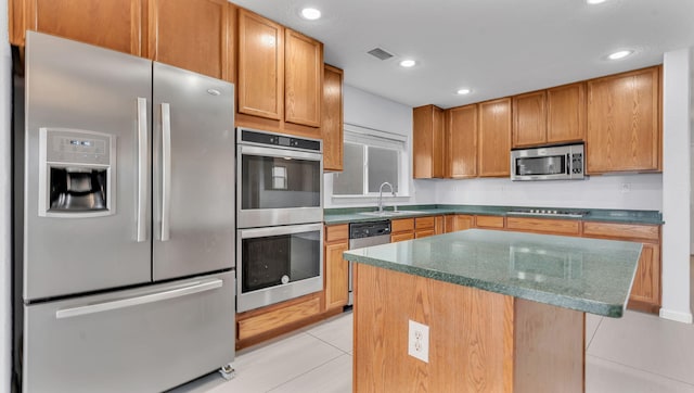 3536 Clear Creek Pl, Rio Rancho, NM 87144 - kitchen featuring stainless steel appliances, light tile patterned flooring, a center island, dark stone countertops, and recessed lighting