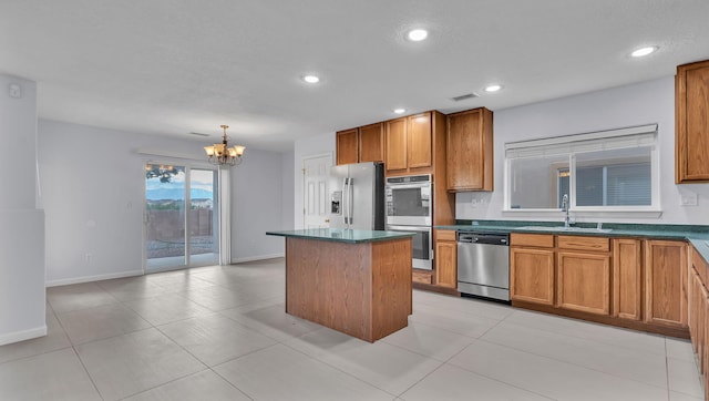 3536 Clear Creek Pl, Rio Rancho, NM 87144 - kitchen featuring appliances with stainless steel finishes, a center island, a chandelier, brown cabinetry, and recessed lighting