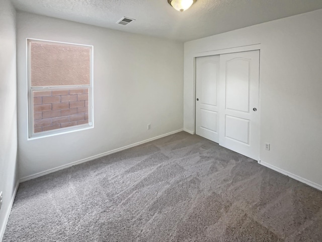 1225 La Fonda St, Bernalillo, NM 87004 - unfurnished bedroom featuring carpet floors, a closet, and a textured ceiling
