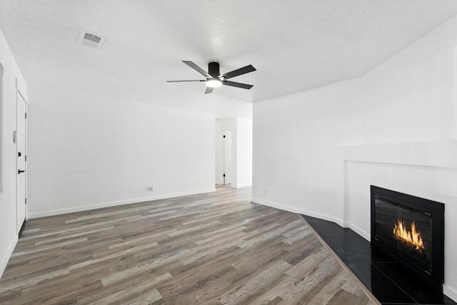 9638 Morrow Ave NE, Albuquerque, NM 87112 - unfurnished living room featuring a glass covered fireplace, wood finished floors, and a ceiling fan