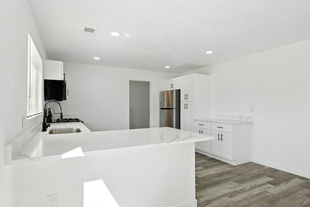 9638 Morrow Ave NE, Albuquerque, NM 87112 - kitchen featuring freestanding refrigerator, a peninsula, light wood-style flooring, recessed lighting, and white cabinetry