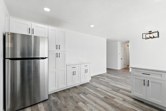 9638 Morrow Ave NE, Albuquerque, NM 87112 - kitchen with freestanding refrigerator, light wood finished floors, recessed lighting, and white cabinetry