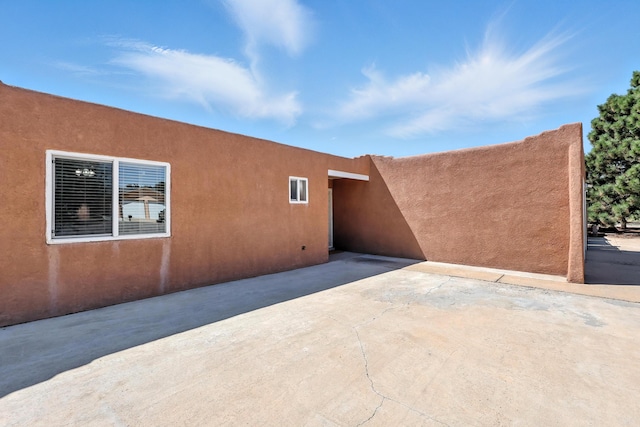 120 Itasca Rd SE, Rio Rancho, NM 87124 - view of property exterior featuring stucco siding and a patio area