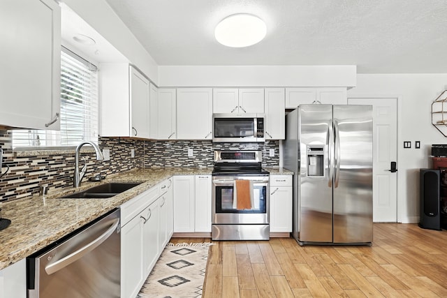 120 Itasca Rd SE, Rio Rancho, NM 87124 - kitchen with appliances with stainless steel finishes, white cabinetry, decorative backsplash, and light stone countertops