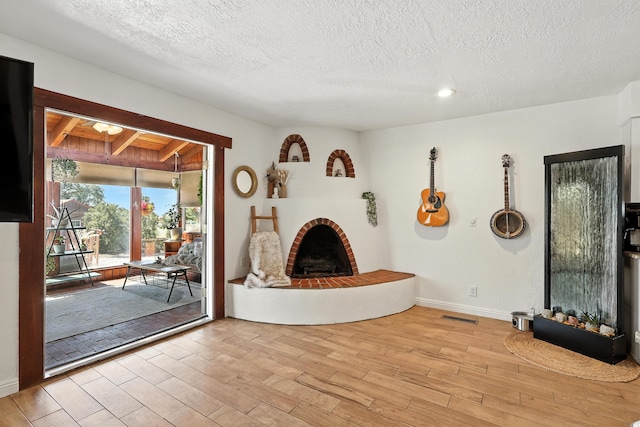120 Itasca Rd SE, Rio Rancho, NM 87124 - unfurnished living room featuring a brick fireplace, wood finished floors, a textured ceiling, and recessed lighting