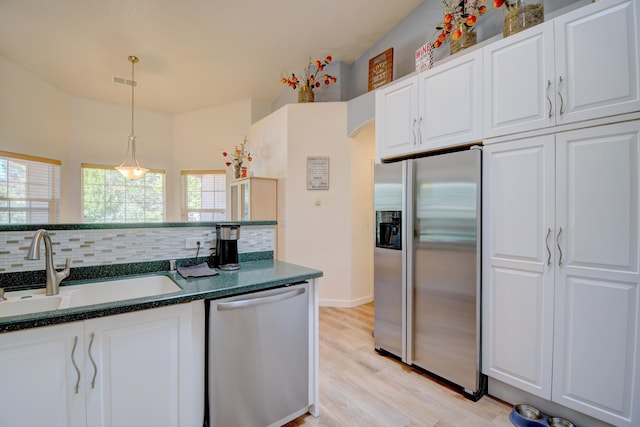 2 Partridge Ct, Peralta, NM 87042 - kitchen featuring stainless steel appliances, tasteful backsplash, light wood-type flooring, white cabinets, and pendant lighting