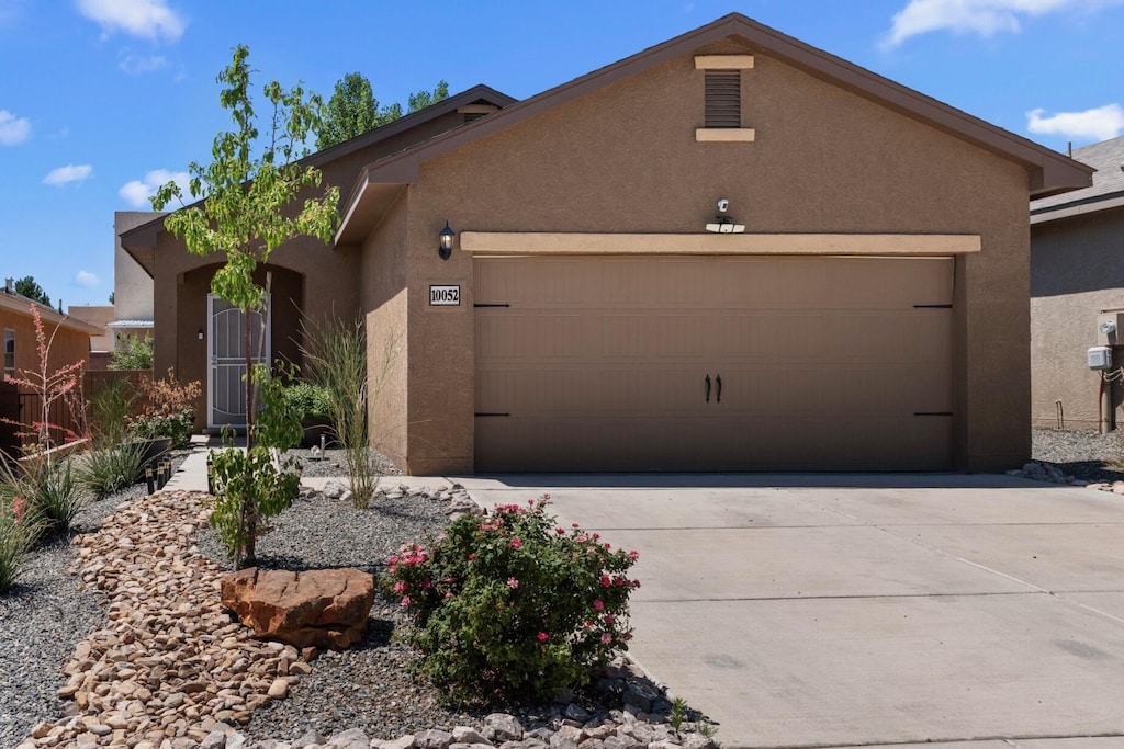 10052 Sacate Blanco Ave SW, Albuquerque, NM 87121 - view of front facade featuring stucco siding, an attached garage, and driveway