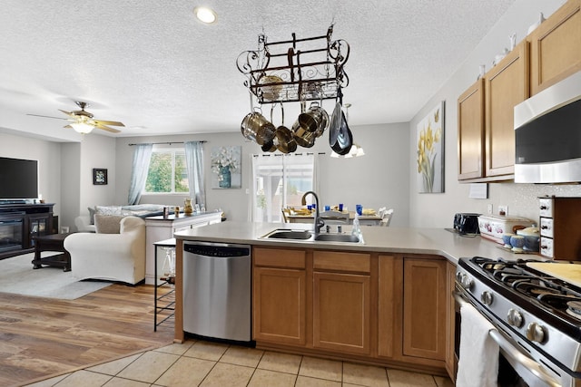 1969 Cortina Loop SE, Albuquerque, NM 87124 - kitchen featuring stainless steel appliances, a peninsula, light countertops, open floor plan, and a textured ceiling