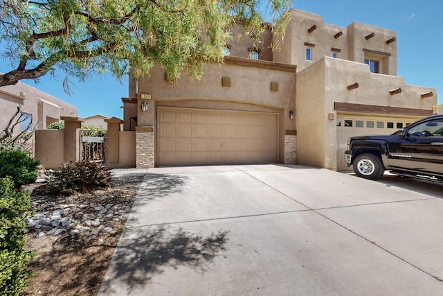 1969 Cortina Loop SE, Albuquerque, NM 87124 - pueblo-style house featuring driveway, an attached garage, stucco siding, and stone siding