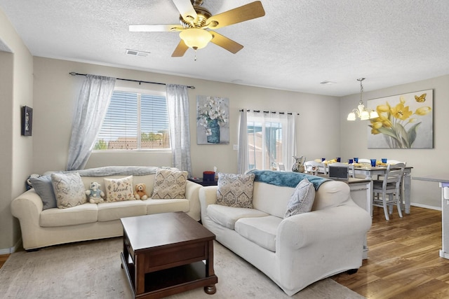 1969 Cortina Loop SE, Albuquerque, NM 87124 - living area featuring wood finished floors, a textured ceiling, a chandelier, and a ceiling fan