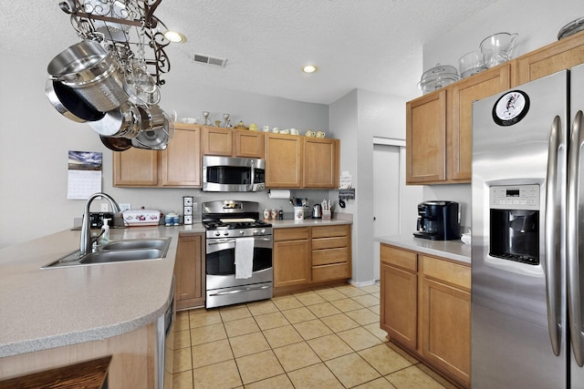 1969 Cortina Loop SE, Albuquerque, NM 87124 - kitchen with stainless steel appliances, light countertops, light tile patterned floors, a textured ceiling, and recessed lighting