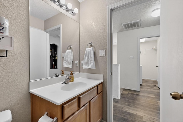 1969 Cortina Loop SE, Albuquerque, NM 87124 - bathroom with wood finished floors, vanity, and a textured wall
