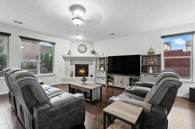 43 Vista Larga Pl NE, Rio Rancho, NM 87124 - living area featuring a textured ceiling, plenty of natural light, a fireplace, and wood finished floors