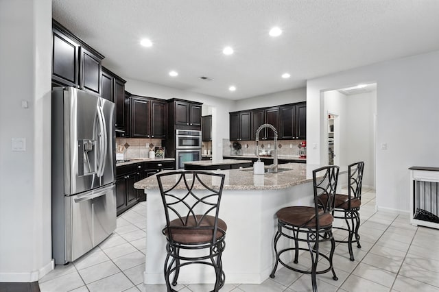 43 Vista Larga Pl NE, Rio Rancho, NM 87124 - kitchen featuring appliances with stainless steel finishes, a spacious island, a kitchen breakfast bar, decorative backsplash, and recessed lighting