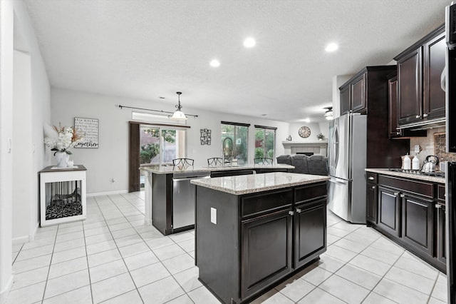 43 Vista Larga Pl NE, Rio Rancho, NM 87124 - kitchen with stainless steel appliances, a center island, light tile patterned floors, recessed lighting, and tasteful backsplash