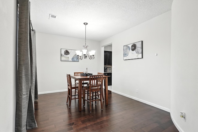43 Vista Larga Pl NE, Rio Rancho, NM 87124 - dining area with a chandelier, dark wood-type flooring, and a textured ceiling
