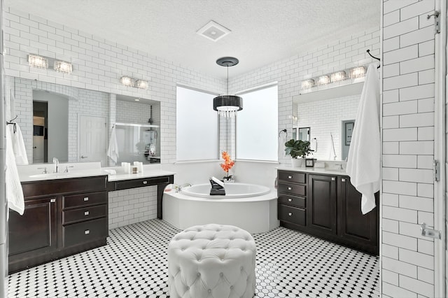 43 Vista Larga Pl NE, Rio Rancho, NM 87124 - bathroom featuring tile patterned floors, a shower stall, two vanities, tile walls, and a garden tub