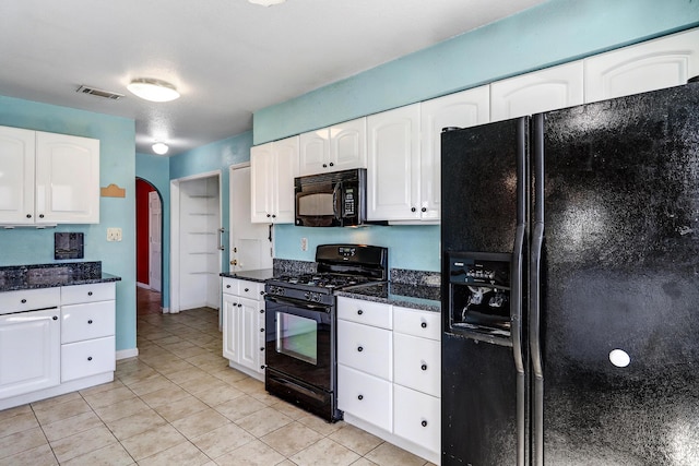 6054 Jack Rabbit Rd NE, Rio Rancho, NM 87144 - kitchen with black appliances, white cabinets, arched walkways, light tile patterned floors, and dark stone countertops