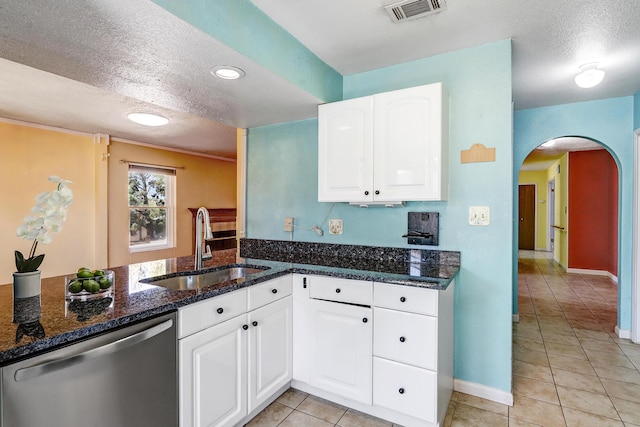 6054 Jack Rabbit Rd NE, Rio Rancho, NM 87144 - kitchen featuring stainless steel dishwasher, arched walkways, light tile patterned flooring, a textured ceiling, and white cabinetry
