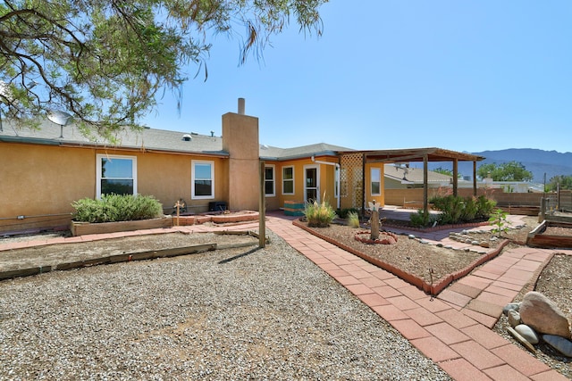 6054 Jack Rabbit Rd NE, Rio Rancho, NM 87144 - rear view of property with a mountain view, a patio area, a chimney, and stucco siding