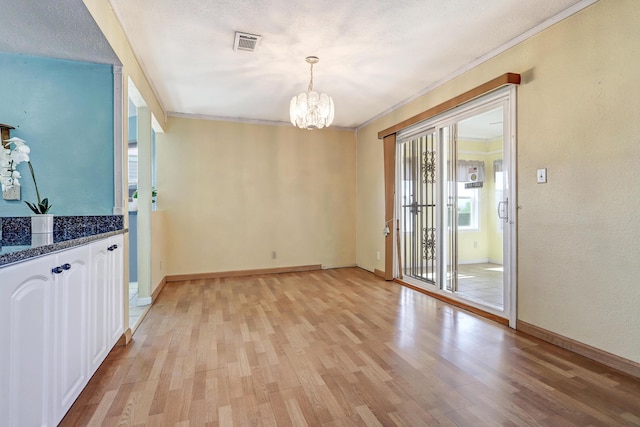 6054 Jack Rabbit Rd NE, Rio Rancho, NM 87144 - unfurnished dining area featuring a chandelier, light wood finished floors, and crown molding