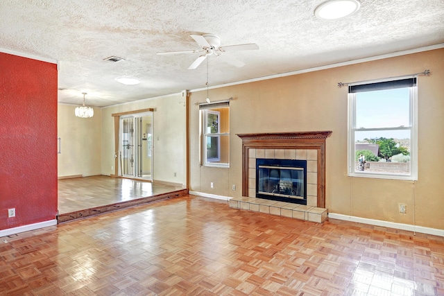 6054 Jack Rabbit Rd NE, Rio Rancho, NM 87144 - unfurnished living room featuring a ceiling fan, a chandelier, a textured ceiling, a tiled fireplace, and crown molding