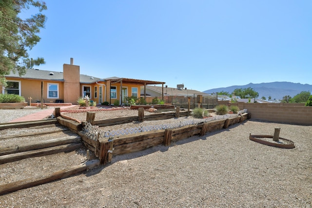 6054 Jack Rabbit Rd NE, Rio Rancho, NM 87144 - back of property with a garden, a mountain view, and a chimney
