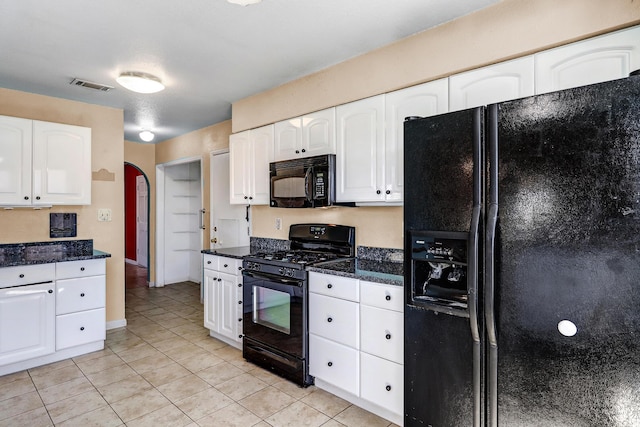 6054 Jack Rabbit Rd NE, Rio Rancho, NM 87144 - kitchen featuring black appliances, white cabinets, arched walkways, light tile patterned floors, and dark stone counters