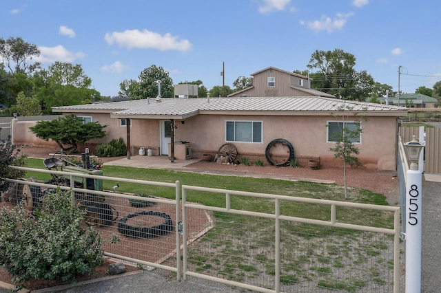 855 Foxcroft Loop, Bosque Farms, NM 87068 - view of front of property featuring a fenced front yard, stucco siding, a gate, and a metal roof