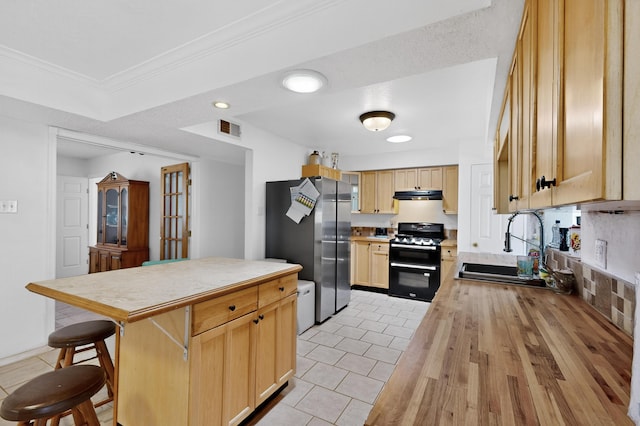 855 Foxcroft Loop, Bosque Farms, NM 87068 - kitchen featuring double oven range, freestanding refrigerator, under cabinet range hood, light brown cabinetry, and light tile patterned floors