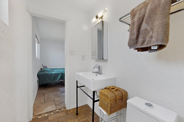 855 Foxcroft Loop, Bosque Farms, NM 87068 - ensuite bathroom with stone tile floors and toilet