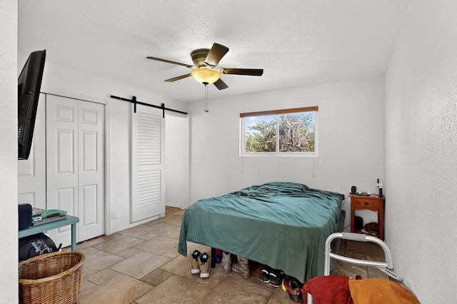 855 Foxcroft Loop, Bosque Farms, NM 87068 - bedroom featuring a barn door, a textured ceiling, and ceiling fan