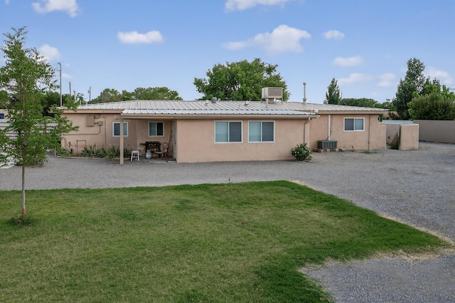 855 Foxcroft Loop, Bosque Farms, NM 87068 - back of property with stucco siding, a yard, a patio, and a metal roof