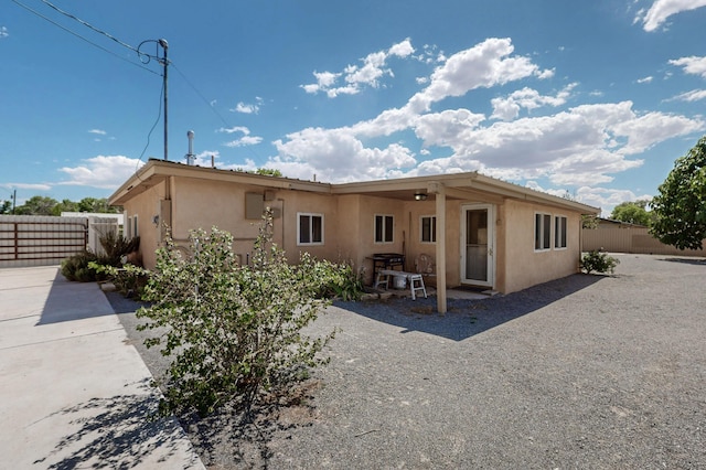855 Foxcroft Loop, Bosque Farms, NM 87068 - rear view of house featuring stucco siding and a patio