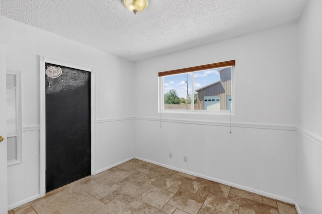 855 Foxcroft Loop, Bosque Farms, NM 87068 - empty room featuring a textured ceiling and light stone finish flooring