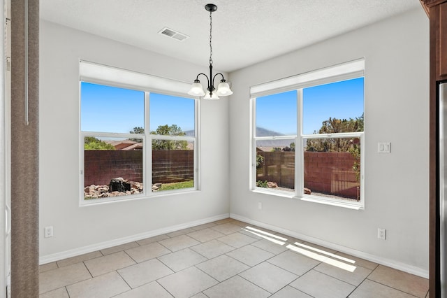 6903 Wrangell Loop NE, Rio Rancho, NM 87144 - spare room featuring a chandelier, light tile patterned flooring, and a textured ceiling
