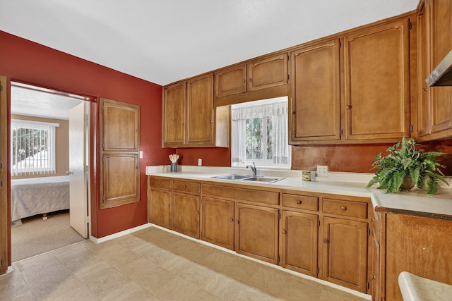 302 Crestview Dr SW, Albuquerque, NM 87105 - kitchen featuring brown cabinets, light countertops, and extractor fan